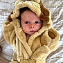 baby, child, face, robe, fur, hood, blanket, bed, soft, cute, curious, indoor, newborn, portrait, clothing, wearing, infant, animal_ears, warm, expression