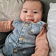 Leyna a rejoint le concours — aidez-le/la à gagner de superbes lots ! baby, cheeks, child, closeup, clothing, couch, cozy, denim_overalls, eyes, fabric_pattern, face, floral_embroidery, head, heart_buttons, infant, newborn, peach_sleeve, pillow, portrait, smile