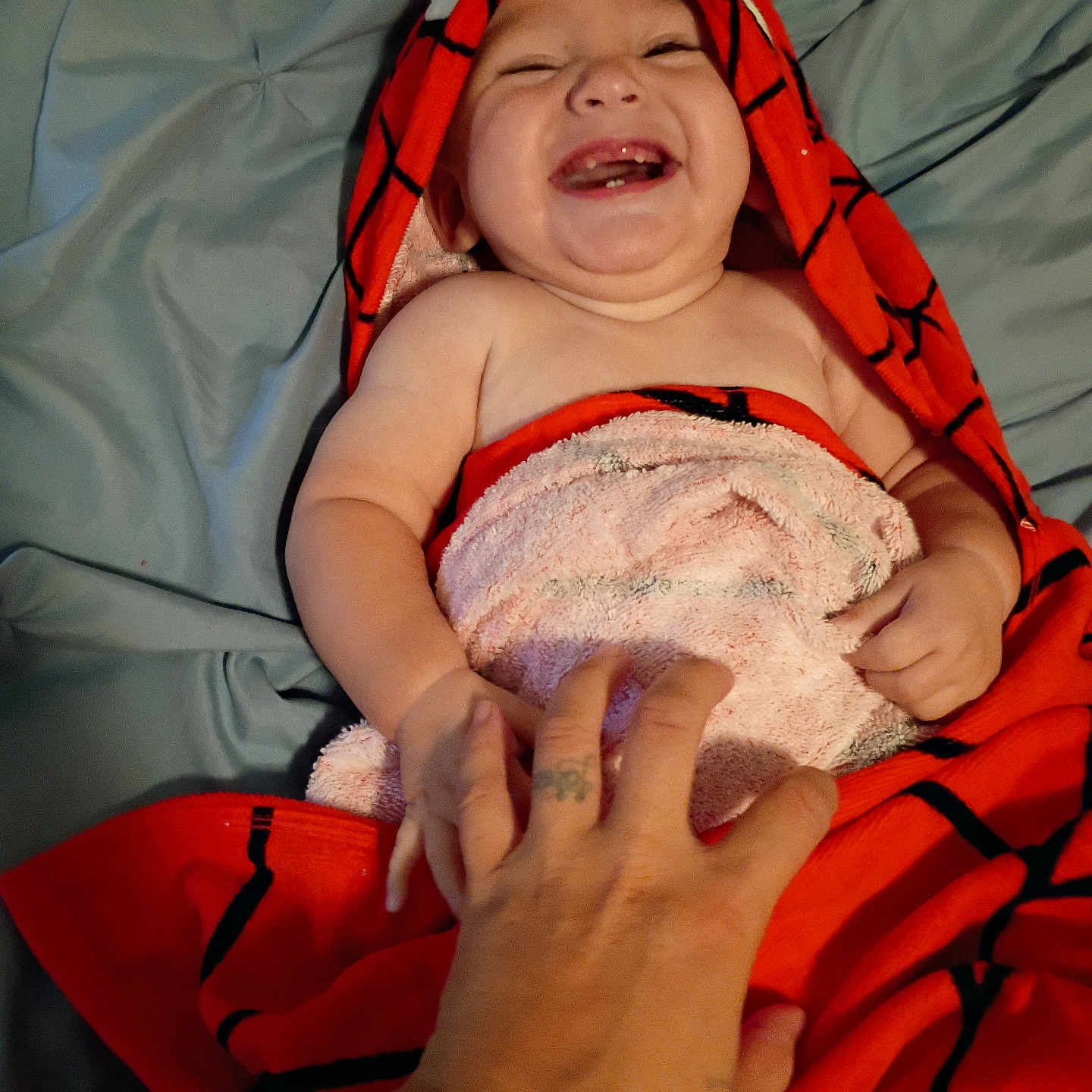 Exavian is registered to the contest to win money with this photo: baby, child, towel, laughing, smiling, hand, tickling, bed, blanket, red, blue, skin, happy, infant, person, cute, playful, cozy, wrapped, indoors