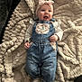baby, denim_overalls, headband, blanket, happy, infant, smiling, clothing, cute, soft_texture, white_socks, portrait, child, indoor, comfortable, fabric, expression, person, toddler, cozy