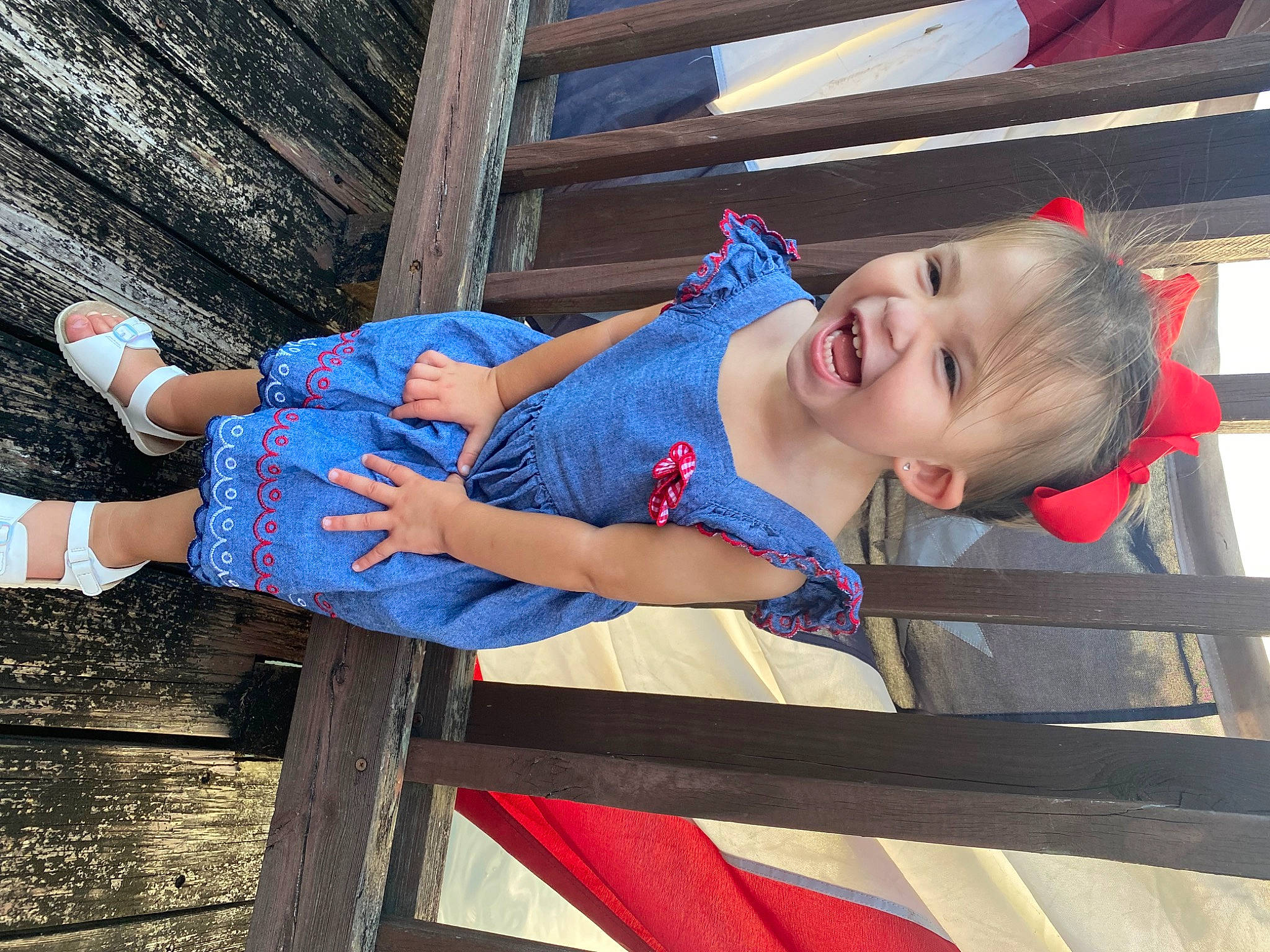 Claire is registered to the contest to win money with this photo: baby_toddler_clothing, blue, child, elbow, electric_blue, fun, happy, hat, human_leg, leisure, person, sitting, sleeve, smile, t_shirt, thigh, toddler, travel, vacation, wood