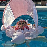 Alix participe au concours pour gagner de l'argent avec cette photo : baby, child, float, fun, hat, inflatable, leisure, outdoor, pacifier, pink, pool, relaxing, sitting, summer, sunglasses, sunny, sunshade, toy, vacation, water