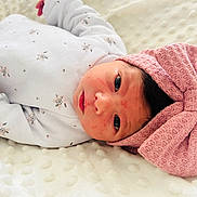 Camille a rejoint le concours — aidez-le/la à gagner de superbes lots ! baby, newborn, infant, lying_down, white_blanket, floral_print, onesie, pink_bow, headband, face, eyes, soft_texture, cute, portrait, indoors, child, newborn_baby, sleepwear, baby_clothing, peaceful