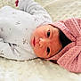 baby, newborn, infant, lying_down, white_blanket, floral_print, onesie, pink_bow, headband, face, eyes, soft_texture, cute, portrait, indoors, child, newborn_baby, sleepwear, baby_clothing, peaceful