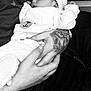 baby, sleeping, infant, knitted_hat, tattoo, hands, black_and_white, cozy_clothing, close_up, peaceful, person, couch, texture, portrait, newborn, resting, soft_light, tenderness, cute, indoor