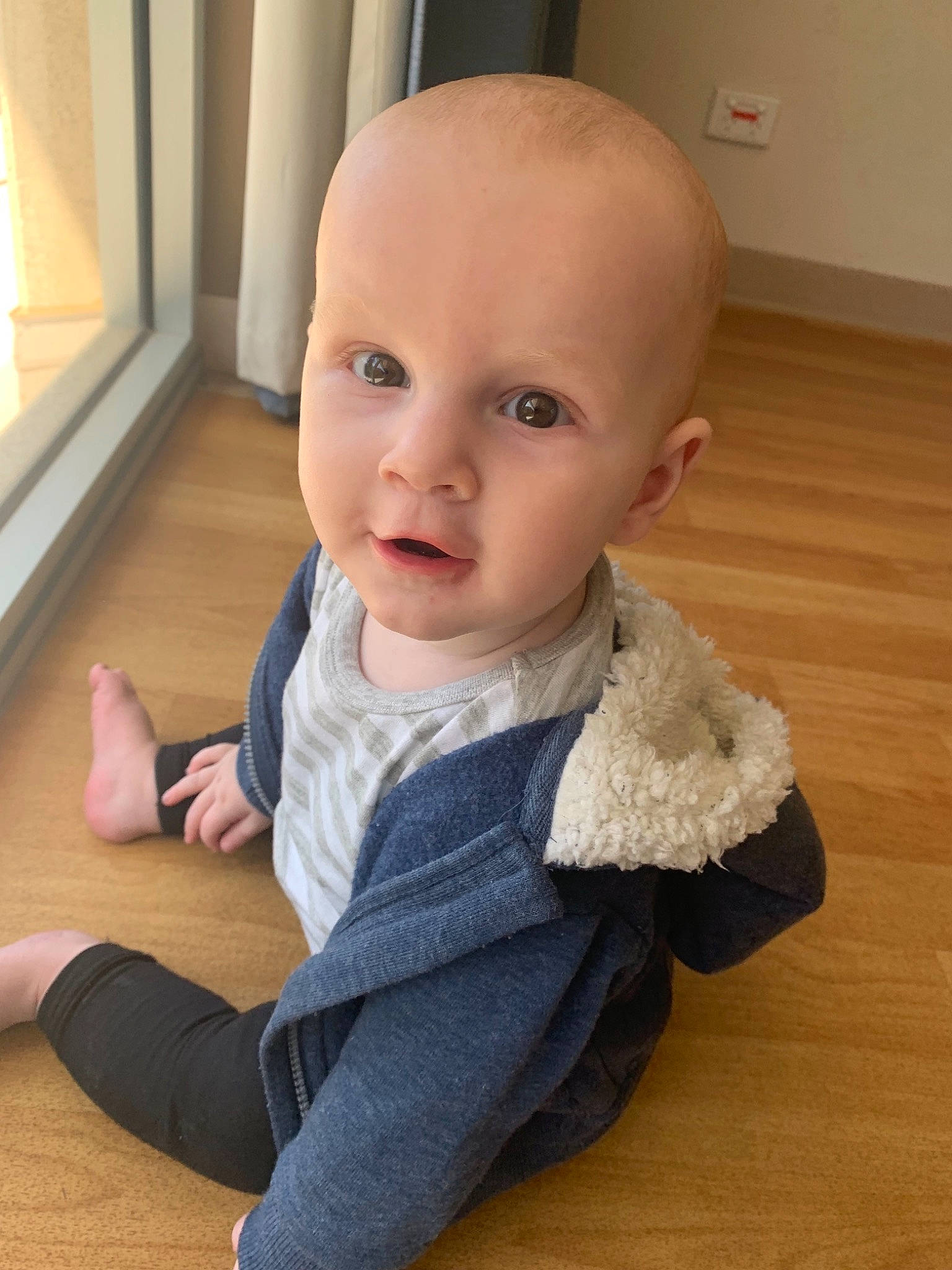 Korbin is registered to the contest to win money with this photo: baby, baby_toddler_clothing, cheek, child, chin, eye, face, finger, floor, flooring, head, leg, lip, nose, outerwear, person, sitting, skin, sleeve, toddler