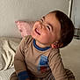Mateo joined the competition — help win amazing prizes! toddler, child, smiling, indoor, bed, pillow, clothing, striped_pants, long_sleeve_shirt, happy, person, cute, face, hair, skin, sitting, cozy, casual, young_child, home