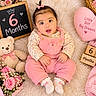 baby, infant, six_months, child, portrait, smiling, sitting, pink, overalls, floral_clothing, hair_bow, teddy_bear, flowers, bouquet, chalkboard, wooden_blocks, blanket, nursery, birthday_theme, studio_photography