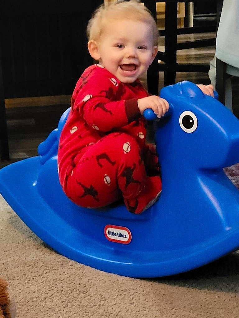 Blake is registered to the contest to win money with this photo: baby, baby_playing_with_toys, baby_toddler_clothing, blue, child, electric_blue, eye, fun, hair, happy, head, leisure, person, photograph, product, recreation, riding_toy, sleeve, smile, toddler