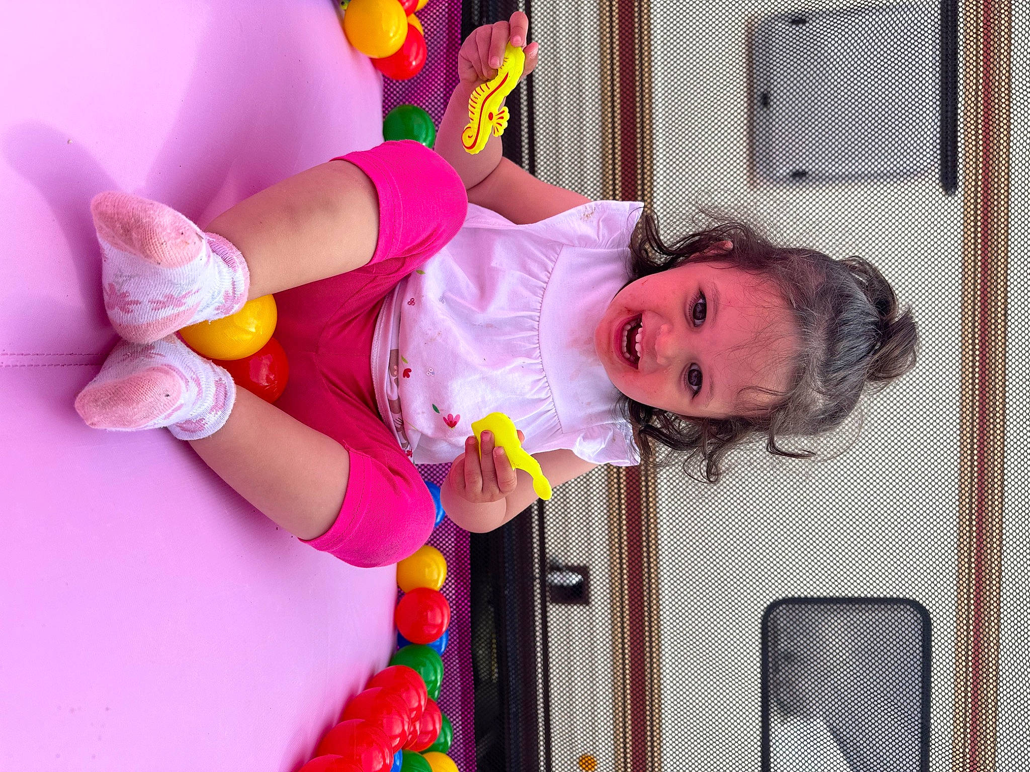 Mia a rejoint le concours — aidez-le/la à gagner de superbes lots ! baby, baby_products, baby_toddler_clothing, baby_toys, child, event, facial_expression, fun, happy, magenta, party, party_supply, person, pink, play, red, room, smile, toddler, toy