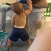 Phoenix joined the competition — help win amazing prizes! baby, toddler, child, adult, playpen, diaper, shorts, back_of_head, face, mesh, interaction, parent, bonding, toy_rings, pacifier, indoor, floor, portrait, casual, nursery