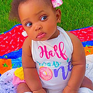 Elorah joined the competition — help win amazing prizes! baby, child, grass, outdoor, quilt, colorful, bow, clothing, cute, infant, sitting, face, portrait, leg_warmers, pink, white, expression, summer, nature, toddler