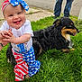 Violet is registered to the contest to win money with this photo: baby, child, dog, grass, outdoor, happy, smiling, person, animal, pet, clothing, headband, street, sidewalk, pants, holding_hands, blue_eyes, fur, tongue_out, casual