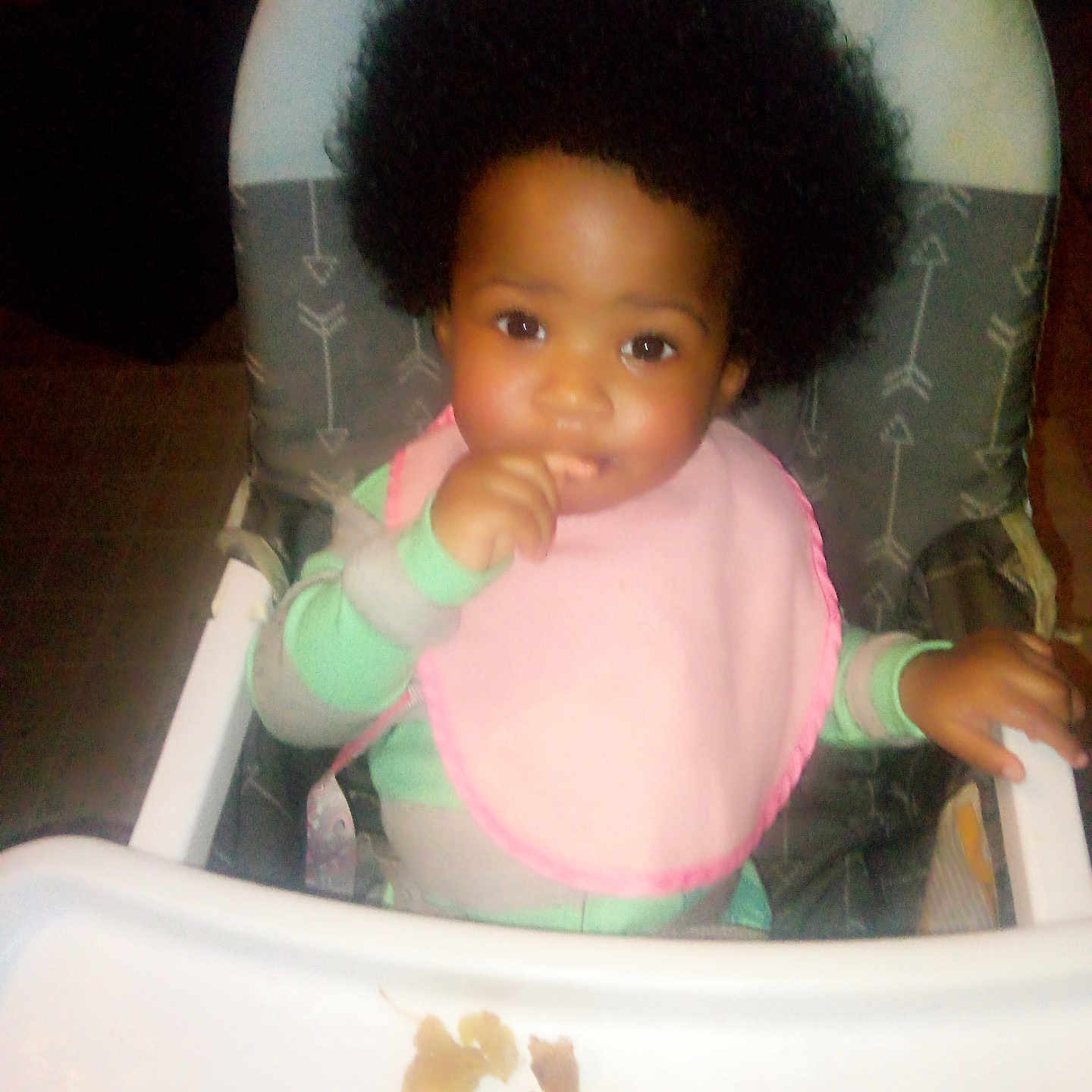 La'Nasia Major is registered to the contest to win money with this photo: afro, baby, bib, child, clothing, curly_hair, cute, face, feeding, food, hand, high_chair, indoor, infant, person, seat, smiling, table, tray, young_child
