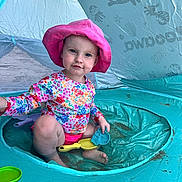 Aurale joined the competition — help win amazing prizes! toddler, child, pink_hat, floral_shirt, swimwear, inflatable_pool, beach_tent, sand_toys, sitting, play, outdoor, summer, water, beach, toy_shovel, toy_sand_mold, cute, sun_protection, fun, smiling