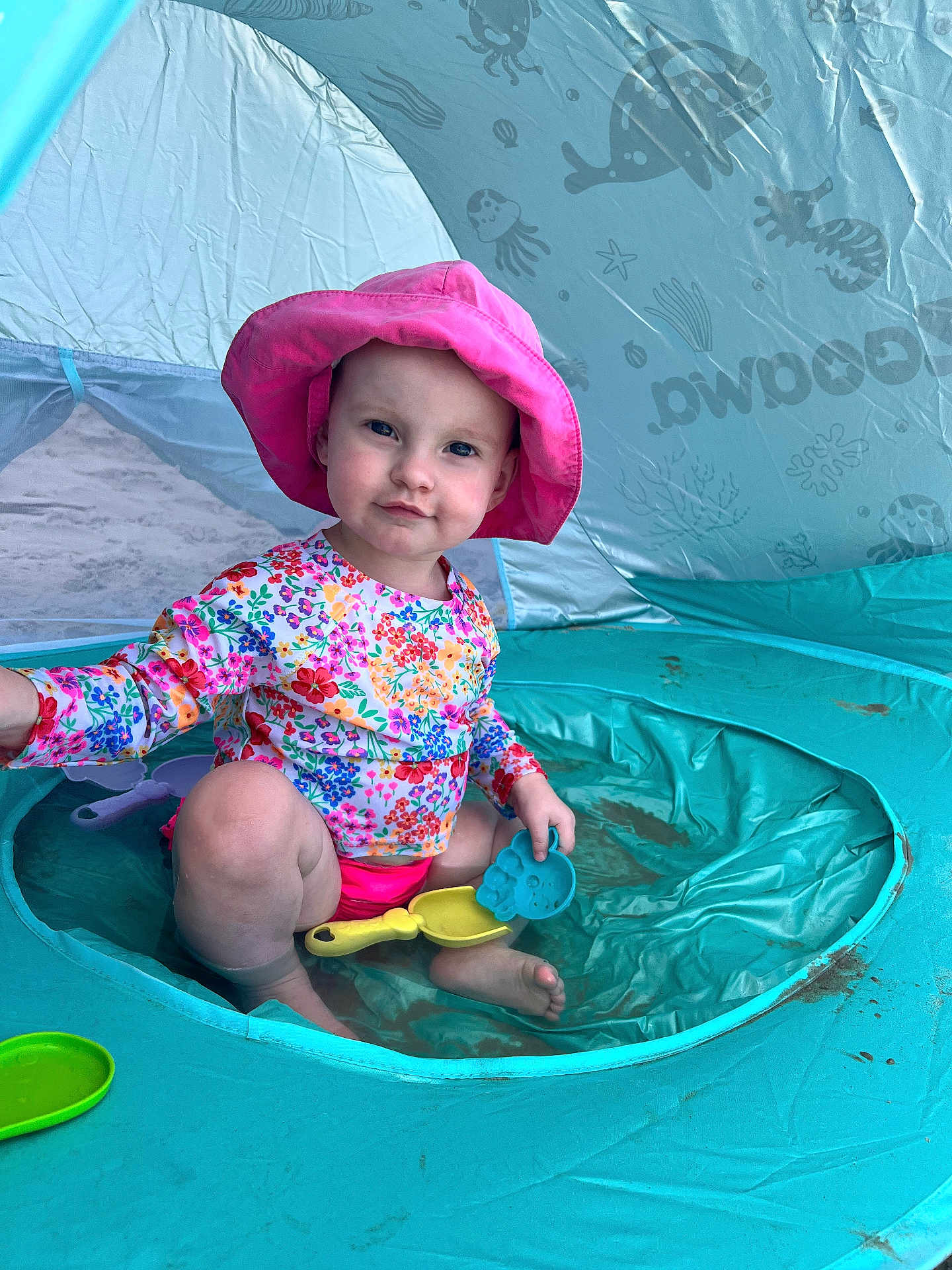 Aurale joined the competition — help win amazing prizes! toddler, child, pink_hat, floral_shirt, swimwear, inflatable_pool, beach_tent, sand_toys, sitting, play, outdoor, summer, water, beach, toy_shovel, toy_sand_mold, cute, sun_protection, fun, smiling