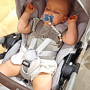 Jules a rejoint le concours — aidez-le/la à gagner de superbes lots ! baby, sleeping, stroller, pacifier, child, indoor, casual_clothing, gray, white, safety_harness, cute, peaceful, infant, floor, footwear, hand, relaxing, shopping_area, person, toddler