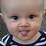 baby, child, tongue_out, striped_shirt, fire_truck_patch, cute, portrait, face, big_eyes, infant, cheeky, close_up, smiling, adorable, young_child, indoor, person, head, expression, clothing
