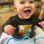 baby, child, smiling, dinosaur, black_shirt, high_chair, toy, happy, indoor, hands, face, mouth_open, cute, infant, playful, clothing, person, expression, closeup, seated