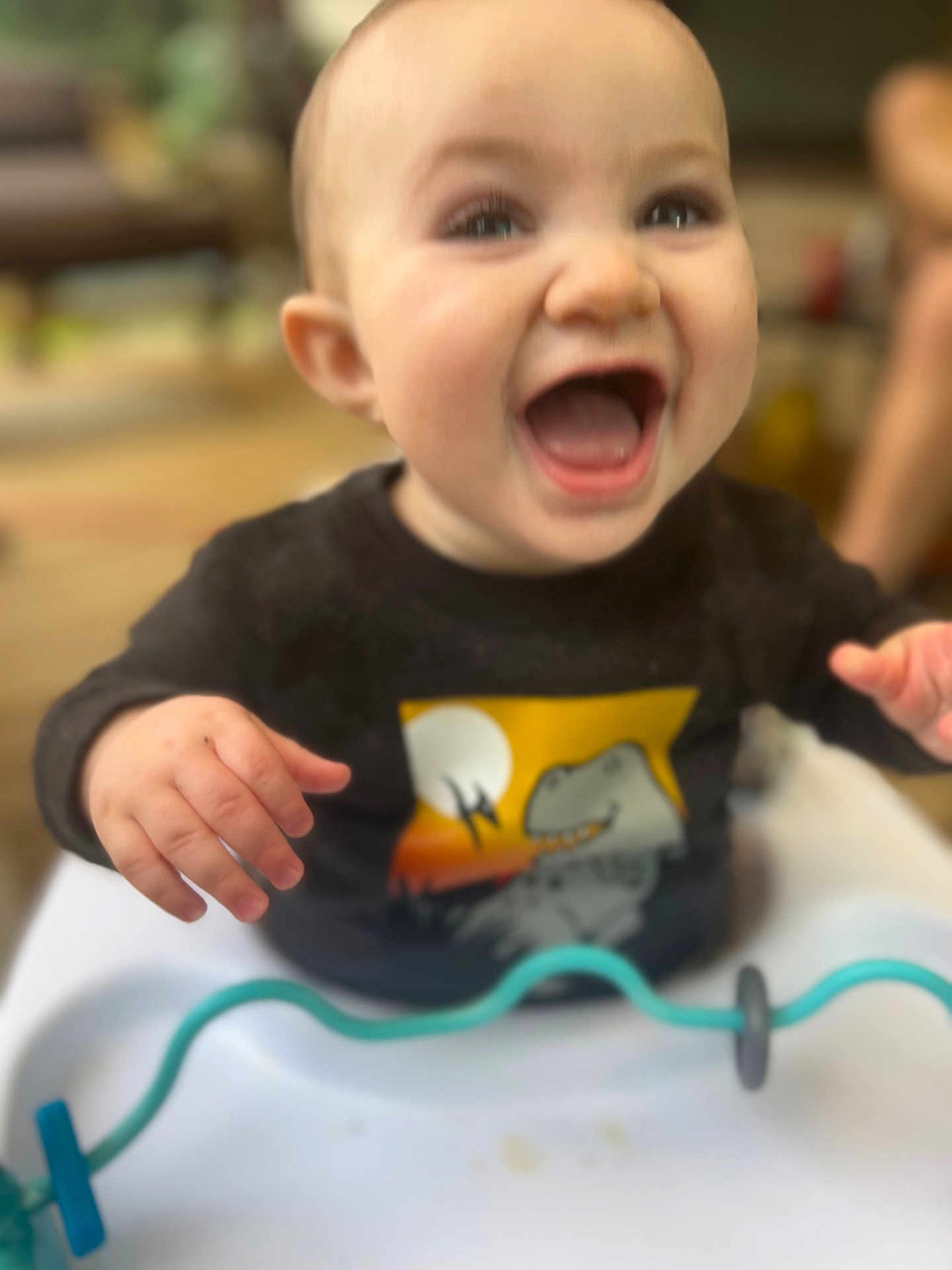 Roman joined the competition — help win amazing prizes! baby, child, smiling, dinosaur, black_shirt, high_chair, toy, happy, indoor, hands, face, mouth_open, cute, infant, playful, clothing, person, expression, closeup, seated