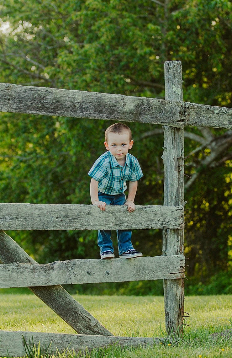 Chase is registered to the contest to win money with this photo: baby_toddler_clothing, child, clothing, fence, fun, glasses, grass, happy, landscape, leaf, leisure, people_in_nature, person, plant, recreation, shorts, sitting, summer, toddler, tree