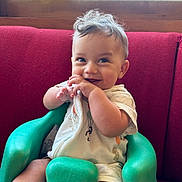 Denim is registered to the contest to win money with this photo: baby, bodypart, chair, couch, cream, cushion, dessert, face, finger, food, furniture, hand, happy, head, icecream, person, photography, portrait, sitting, smile