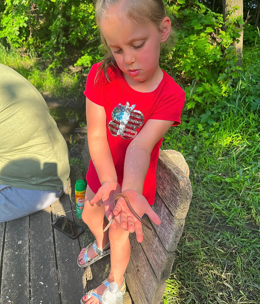 Hazel joined the competition — help win amazing prizes! baby_toddler_clothing, child, fun, grass, happy, human_leg, lawn, leisure, people_in_nature, person, plant, recreation, sandal, sitting, soil, summer, t_shirt, terrestrial_plant, thigh, toddler