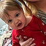 Sydney joined the competition — help win amazing prizes! baby, child, adult, glasses, red_onesie, dog_prints, hand, bedroom, blanket, curtain, smile, face, person, indoor, closeup, holding, light, hair, expression, cozy