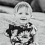 child, toddler, smiling, portrait, black_and_white, flower_pattern, sunflower, happy, cute, face, short_hair, baby, clothing, person, infant, outdoor, sitting, young_child, joyful, closeup