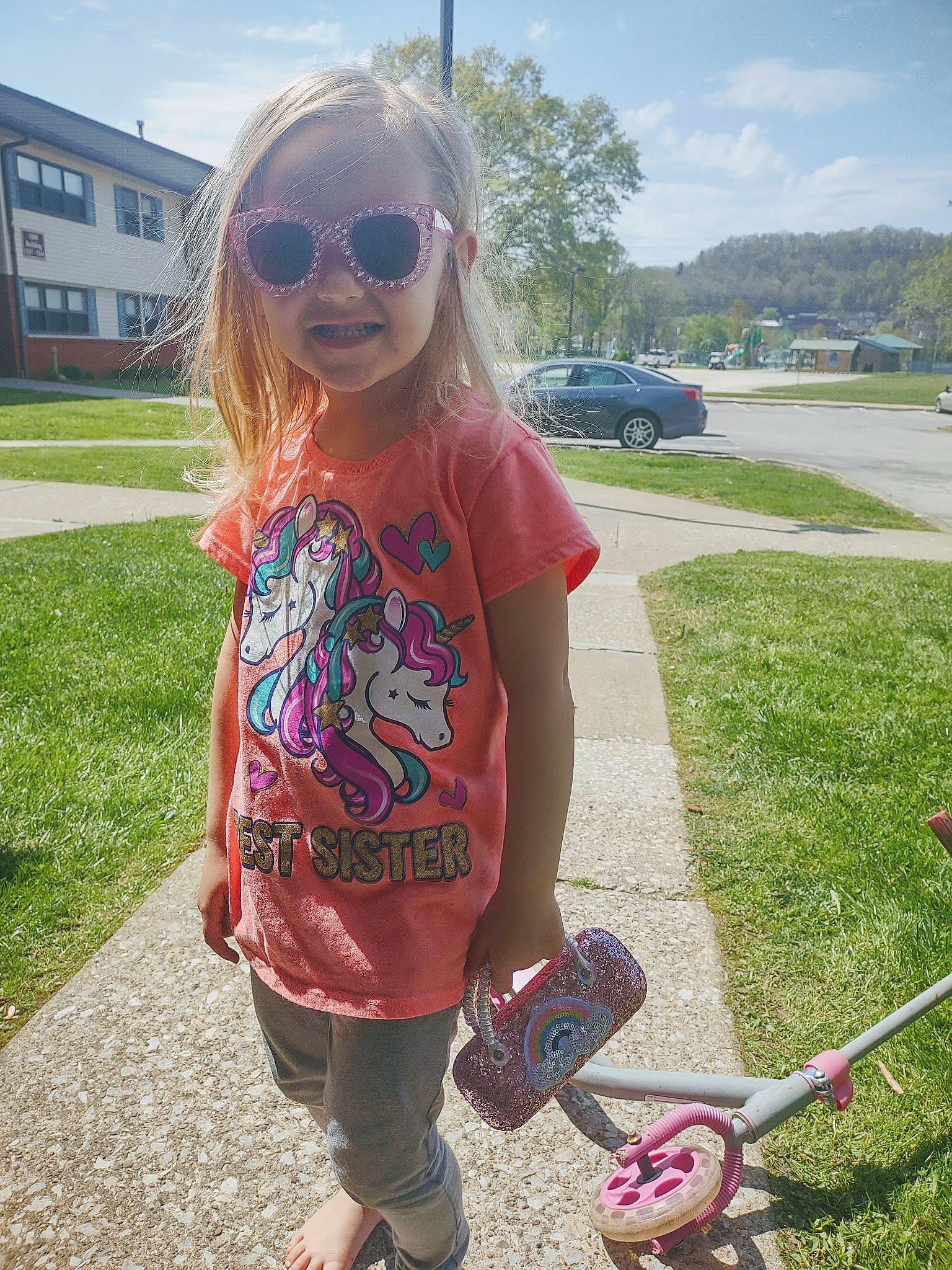 Kinsley is registered to the contest to win money with this photo: car, cloud, cool, eyewear, fun, glasses, goggles, grass, hairstyle, person, pink, plant, sky, sleeve, smile, sunglasses, tire, vehicle, vision_care, white