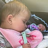 baby, infant, sleeping, car_seat, vehicle, seatbelt, teething_toy, toy, pink_bib, blanket, hand, portrait, close_up, face, blond_hair, child, indoors, travel, airplane_safety_sticker, peaceful