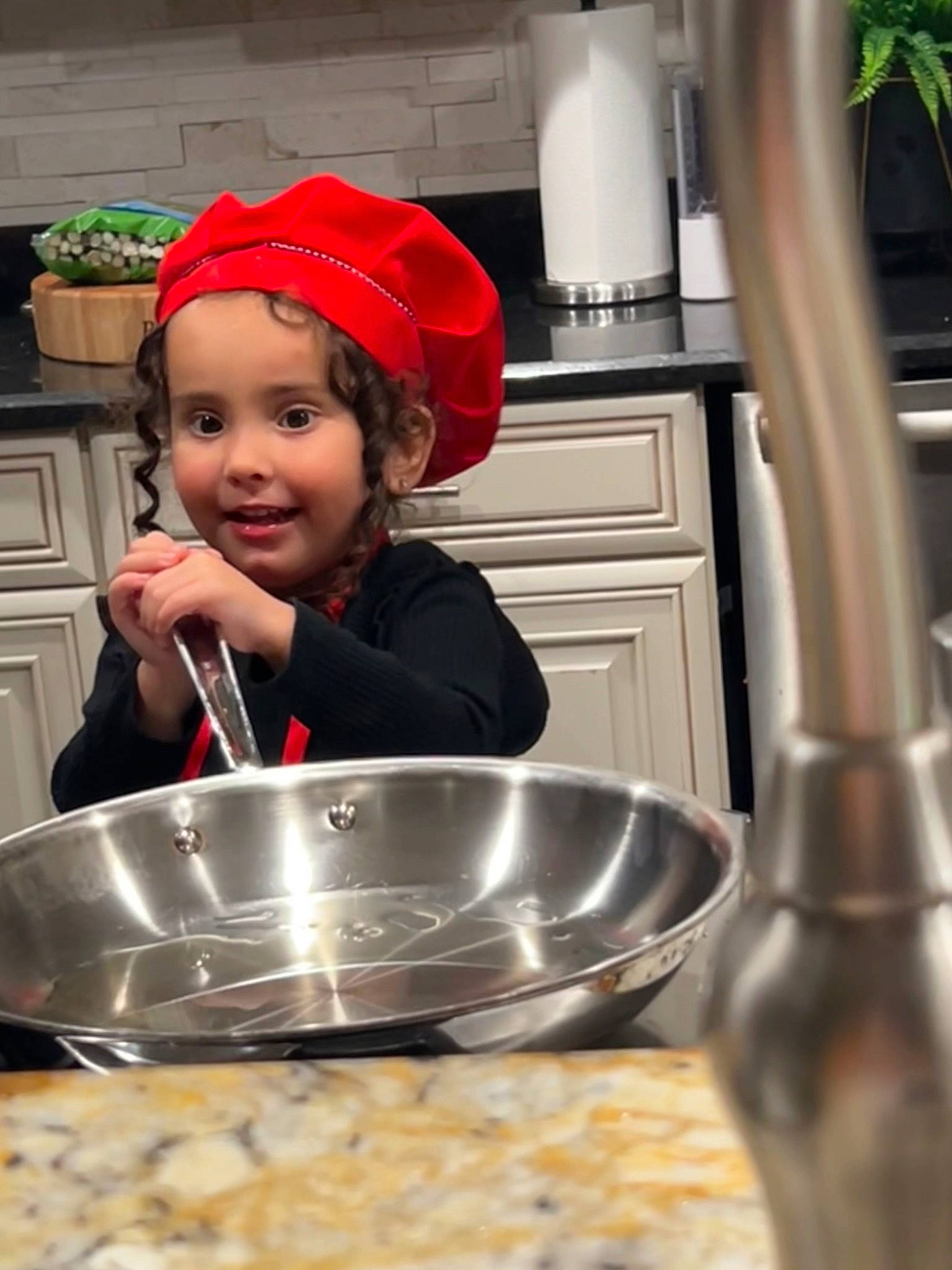 Reign is registered to the contest to win money with this photo: baby, bowl, child, cook, cooking, cookware_and_bakeware, cuisine, dish, event, food, headwear, ingredient, kitchen, kitchen_utensil, people, person, plant, recipe, room, smile