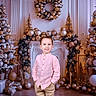 Lyam participe au concours pour gagner de l'argent avec cette photo : child, boy, smile, pink_shirt, beige_pants, christmas_tree, wreath, ornaments, gifts, holiday, festive, decorations, indoor, portrait, holiday_season, holiday_decor, celebration, happy, pose, festivity