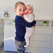 Myla a rejoint le concours — aidez-le/la à gagner de superbes lots ! child, baby, boy, hug, indoor, mirror, plant, furniture, smile, casual_clothing, shoes, headband, floor, cabinet, modern, curious, cute, affection, family, portrait