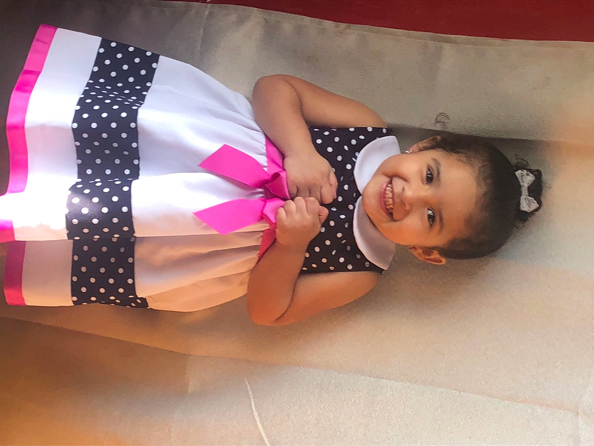 Clarissa is registered to the contest to win money with this photo: abdomen, baby, baby_laughing, baby_toddler_clothing, child_model, joy, person, pink, polka_dot, stomach, trunk