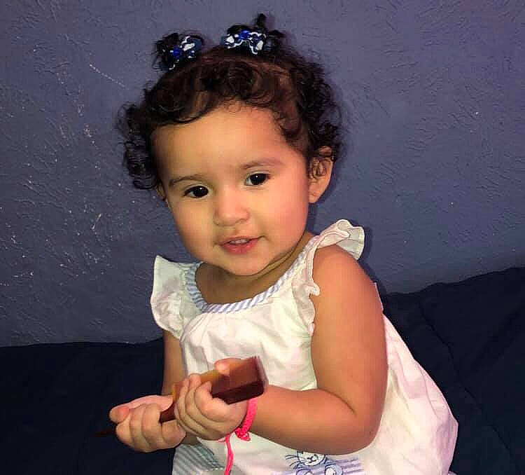 Clarissa is registered to the contest to win money with this photo: arm, baby, brown_hair, cheek, child, child_model, fashion_accessory, hair, hair_accessory, hairstyle, headband, headgear, headpiece, person, smile, tiara, toddler