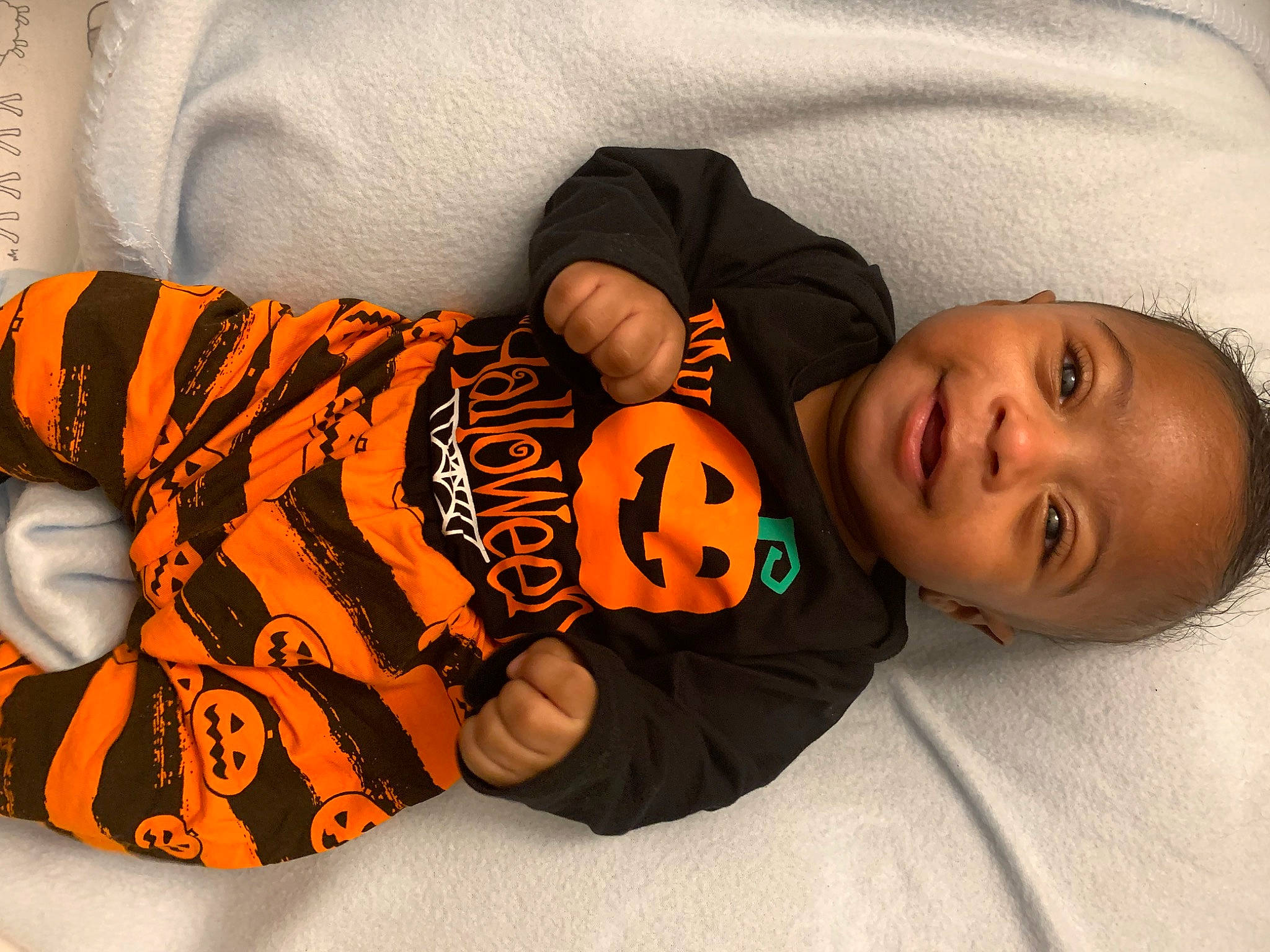 Romell is registered to the contest to win money with this photo: baby, baby_products, baby_sleeping, baby_toddler_clothing, cheek, child, clothing, comfort, human_body, linens, orange, pattern, person, room, sitting, sleep, sleeve, smile, toddler, vertebrate