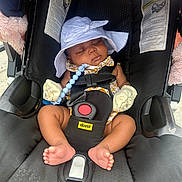 A'Jshanae is registered to the contest to win money with this photo: baby, sleeping, car_seat, doona, hat, mittens, infant, child, footwear, toy, black, white, comfort, seatbelt, cute, peaceful, outdoor, sun_hat, safety, plush