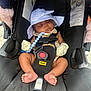 baby, sleeping, car_seat, doona, hat, mittens, infant, child, footwear, toy, black, white, comfort, seatbelt, cute, peaceful, outdoor, sun_hat, safety, plush