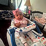 A'Jshanae is registered to the contest to win money with this photo: baby, baby_walker, blanket, child, clothing, colorful, cozy, curious, cute, furniture, home, indoor, infant, lamp, mittens, person, pink_headband, playpen, sitting, soft_lighting