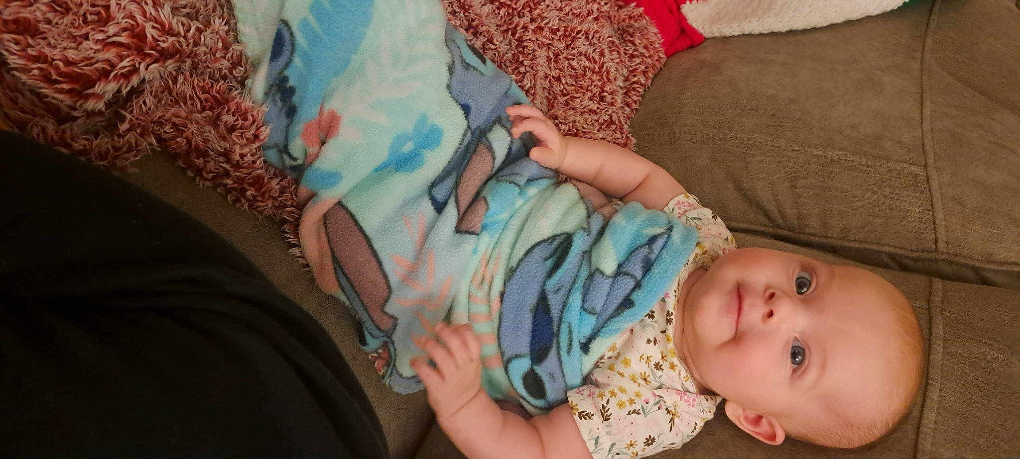 Andrea is registered to the contest to win money with this photo: arm, baby, baby_toddler_clothing, cheek, child, comfort, electric_blue, finger, hand, human_leg, linens, nail, pattern, peach, person, pink, skin, sleeve, thigh, toddler