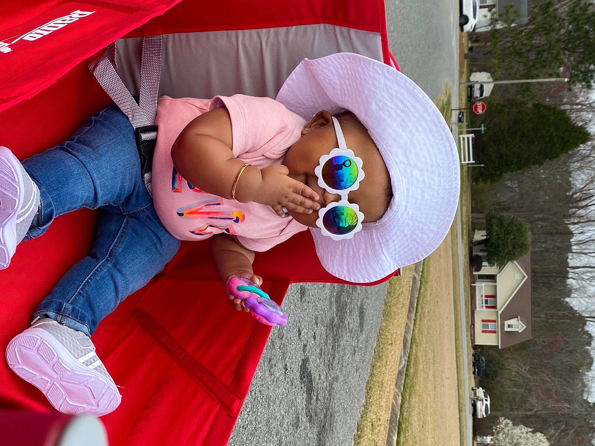 Kiyah is registered to the contest to win money with this photo: event, eyewear, fun, glasses, hat, human_leg, jeans, leg, leisure, musical_instrument, pattern, person, pink, recreation, red, sun_hat, sunglasses, thigh, toy, tree