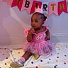Melina is registered to the contest to win money with this photo: baby, child, birthday, tutu, crown, balloons, pink, dress, sitting, polka_dot, blanket, celebration, party, decorations, cute, indoor, girl, footwear, portrait, one_year_old