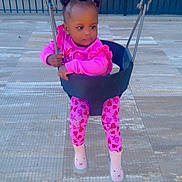 Melina joined the competition — help win amazing prizes! toddler, child, swing, playground, pink_clothing, chains, outdoor, fence, curious, sitting, shoes, patterned_leggings, hairstyle, daytime, tiles, person, young_child, play, fun, baby