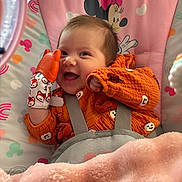 Aurora joined the competition — help win amazing prizes! baby, smiling, orange_clothing, teething_mitten, blanket, baby_chair, minnie_mouse, pink, happy, infant, cute, indoor, child, face, person, soft_texture, toy, seat_belt, playful, cozy