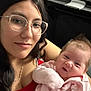 Aurora joined the competition — help win amazing prizes! baby, baby_gear, black_hair, casual, closeup, face, family, glasses, happy, holding, indoor, infant, person, pink_clothing, portrait, red_top, seated, smiling, woman, young_child