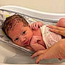 Aurora is registered to the contest to win money with this photo: baby, newborn, infant, bathtub, water, wet_hair, hands, skin, cute, child, person, bath_time, white, polka_dot, cloth, support, care, small, indoors, close_up