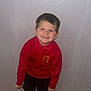 child, boy, smiling, red_sweater, school_uniform, shorts, indoor, wooden_floor, wall, footwear, socks, happy, standing, casual_clothing, portrait, person, cute, playful, spiderman, home