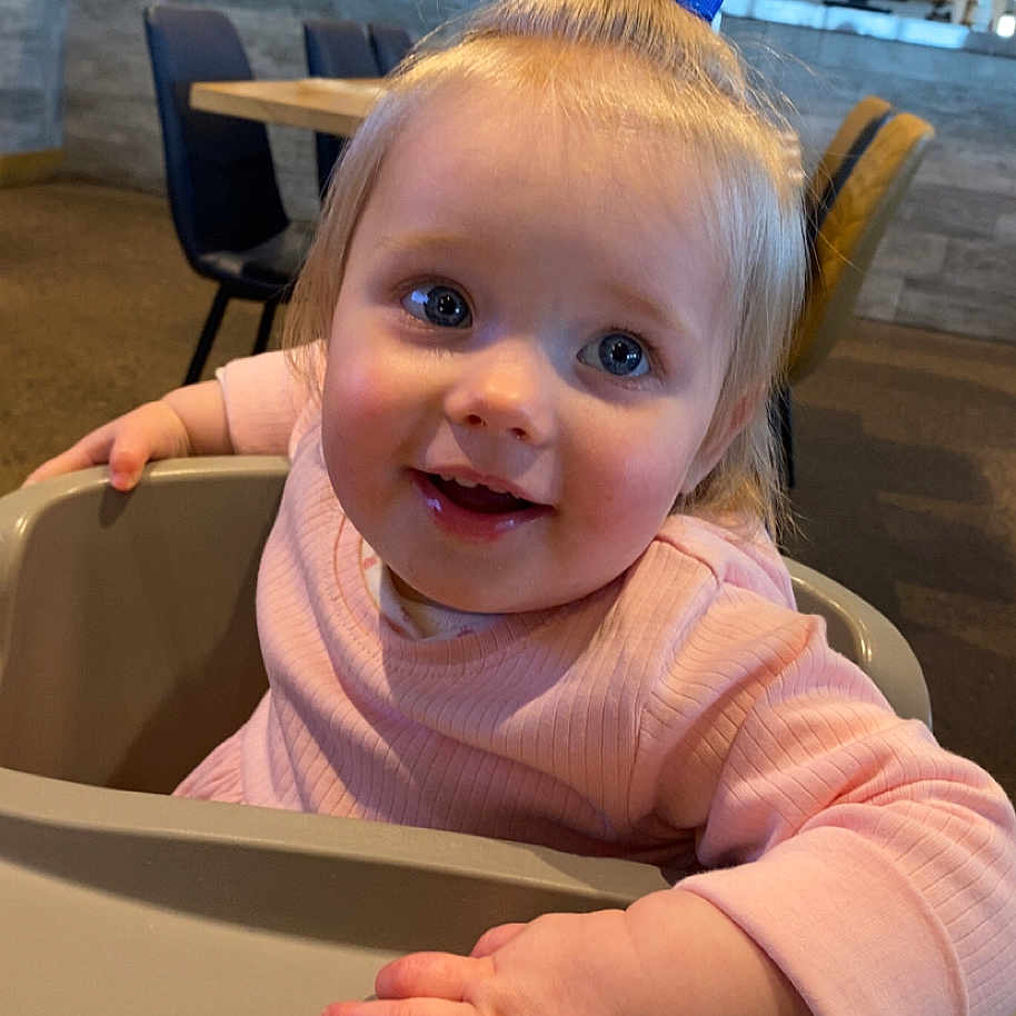 Ava is registered to the contest to win money with this photo: accessories, baby, bodypart, chair, computerhardware, electronics, face, finger, furniture, hand, head, indoors, interiordesign, person, photography, plywood, portrait, restaurant, table, wood