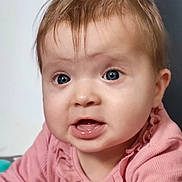 Luna participe au concours pour gagner de l'argent avec cette photo : baby, infant, portrait, close_up, face, blue_eyes, pink_clothing, ruffles, mouth_open, cheeks, eyelashes, light_brown_hair, skin, cute, surprised_expression, indoor, soft_lighting, child, baby_girl, toddler